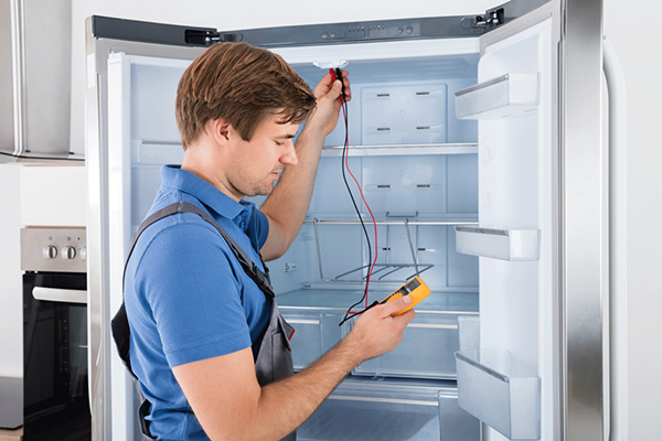 Technician repairing a refrigerator